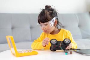 Asia students learn at home in coding robot cars and electronic board cables in STEM, STEAM, mathematics engineering science technology computer code in robotics for kids concept. photo