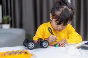 Asia students learn at home in coding robot cars and electronic board cables in STEM, STEAM, mathematics engineering science technology computer code in robotics for kids concept. photo
