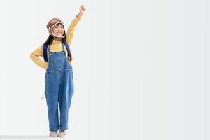 una linda niña vestida con una gorra y gafas de piloto. el niño sueña con convertirse en piloto. foto