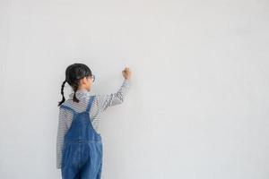 niños pequeños pintando en la pared blanca foto