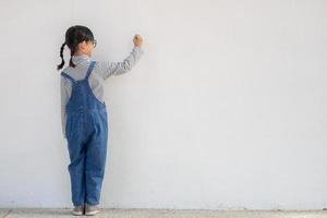 niños pequeños pintando en la pared blanca foto