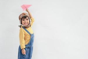 A cute little girl dressed in a cap and glasses of a pilot. The child dreams of becoming a pilot. photo