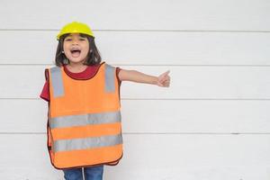 Asian Kid girl wearing reflective shirts and a hat yellow. To learning and enhance development, little architect. photo