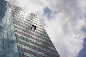 grupo de trabajadores que limpian el servicio de ventanas en un edificio alto foto