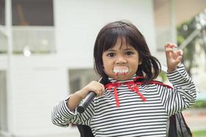 niña con un misterioso vestido de halloween sosteniendo una hoz sobre fondo blanco foto