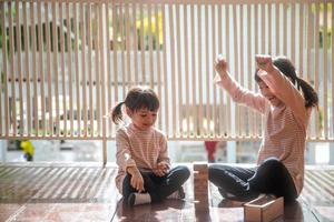 dos chicas asiáticas jugando pilas de madera en casa foto