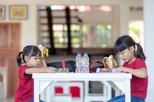 los niños asiáticos en la cantina almorzando o desayunando se divierten foto