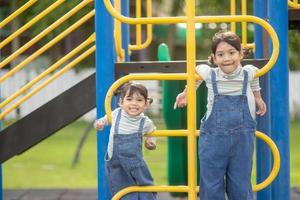 Cute little girls siblings having fun on playground outdoors on a sunny summer day. active sport leisure for kids photo