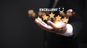 customer hand  with gold five star rating feedback icon and press level excellent rank for giving best score point to review the service, business concept photo