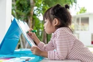 Little kids drawing with a colored pencil is a good activity for improving creative art and handwriting skills in children. Concept picture for education and learning hobby. photo