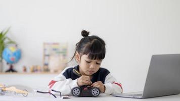 Asia students learn at home in coding robot cars and electronic board cables in STEM, STEAM, mathematics engineering science technology computer code in robotics for kids concept. photo