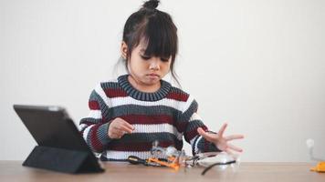 Inventive kid constructing robot cars at home photo