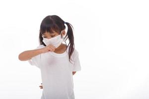 niña asiática con mascarilla para prevenir el virus pm2.5, coronavirus, 2019-ncov niña asiática que se siente mal y tose como síntoma de resfriado o neumonía, de fondo blanco foto