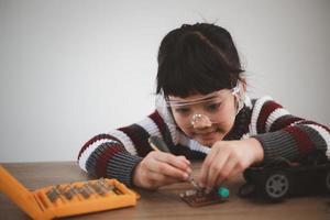 Little girls having fun in a workshop coding robot car photo