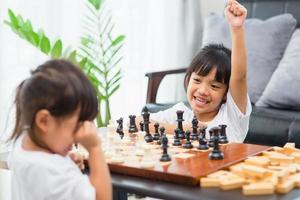 Kids playing chess - one of them just captured a pawn and celebrates photo