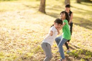 niños jugando tira y afloja en el parque en sunsut foto