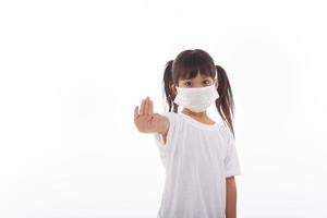 Coronavirus Covid-19.Stay at home Stay safe concept.Little girl wearing mask for protect.show stop hands gesture for stop corona virus outbreak.Coronavirus pandemic virus symptoms. photo