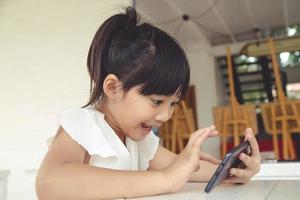 niña usando teléfono inteligente, concepto de redes sociales. foto