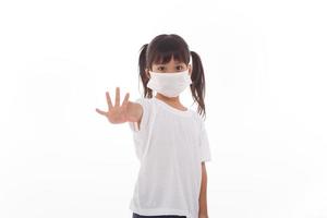 Coronavirus Covid-19.Stay at home Stay safe concept.Little girl wearing mask for protect.show stop hands gesture for stop corona virus outbreak.Coronavirus pandemic virus symptoms. photo