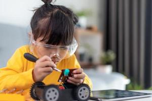 Asia students learn at home in coding robot cars and electronic board cables in STEM, STEAM, mathematics engineering science technology computer code in robotics for kids concept. photo