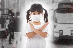 concepto de coronavirus y contaminación del aire pm2.5. niña con máscara para proteger pm2.5 y mostrar el gesto de detener las manos para detener el brote del virus de la corona. coronavirus de wuhan y síntomas del virus epidémico. foto