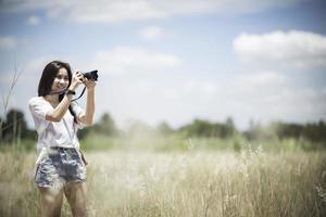 Outdoor summer smiling lifestyle portrait of pretty young woman having fun with camera travel photo of photographer Making pictures