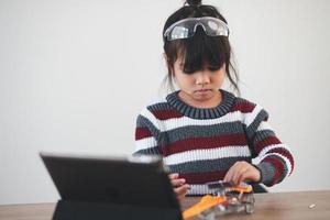 Inventive kid constructing robot cars at home photo