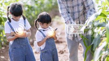 The little girl uses a tablet to analyze the growth of plants in the agricultural plot and visual icon., the agricultural technology concept. smart farming learning Concept photo