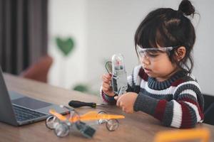 Inventive kid constructing robot cars at home photo
