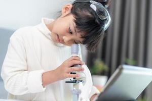 young girl play science experiments for homeschooling photo