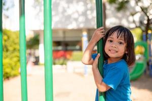 linda niña divirtiéndose en un patio de recreo al aire libre en verano foto