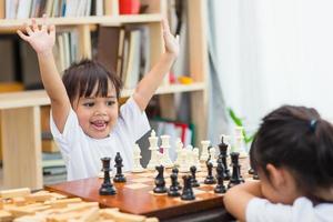 Kids playing chess - one of them just captured a pawn and celebrates photo