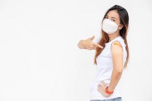 Asian Women Show Bandage On Arm. Happy Asian Woman Feels Good After Received Vaccine On White Background. photo