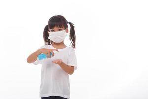 little girl using alcohol gel for cleaning hands.on white background photo