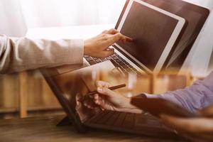 mano de mujer de negocios trabajando con computadora portátil, tableta y teléfono inteligente en la oficina moderna con diagrama de icono virtual en la oficina moderna a la luz de la mañana foto