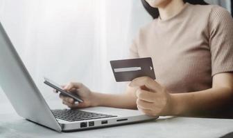 Woman hand using mobile smart phone, online payment, banking and online shopping at the home. photo