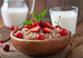 Oatmeal porridge with berries in a white bowl photo