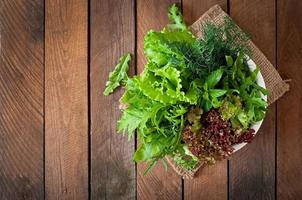 Variety fresh organic herbs  on wooden background in rustic style photo