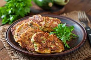 Zucchini pancakes with parsley on a wooden table photo