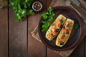 Stuffed zucchini with chicken, tomatoes and olives with cheese crust photo