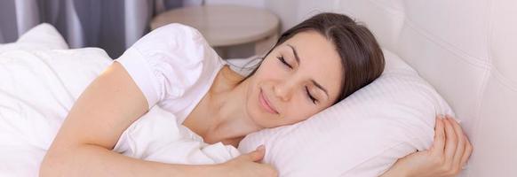 Sleep. Young woman sleeps in bed. Portrait beautiful woman relaxing photo