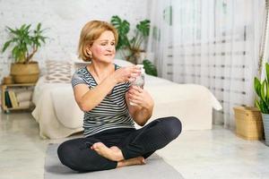 mujer adulta bebiendo agua después de un entrenamiento foto