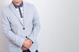 Business man on light background with folded hands on light background in jacket photo