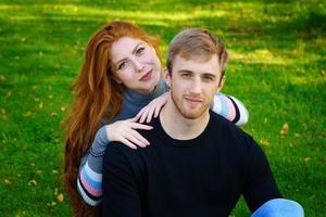 alegre pareja joven en el parque en el césped foto