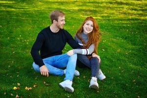 alegre pareja joven en el parque en el césped foto