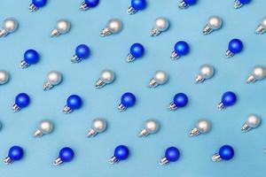 Bolas de decoración navideña azul y plata sobre fondo azul con copia foto