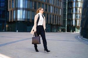 mujer de negocios con abrigo y traje se acerca al negocio foto