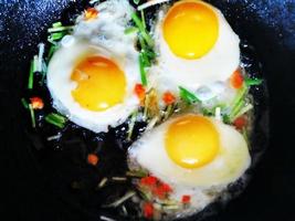 Scrambled eggs with green onions and carrots in a pan while cooking photo