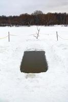 ice hole with frozen water in river photo