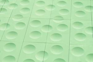 The close-up of green detailed sphere texture reverse side of the plastic tile. Rough embossed lattice. Concept of design. Wall decoration interior. Relief balls geometric pattern. Flatlay, mock up photo
